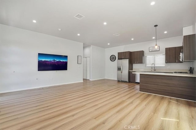 7820 Fulton Ave, North Hollywood, CA 91605 - kitchen with stainless steel appliances, open floor plan, light countertops, light wood finished floors, and dark brown cabinets