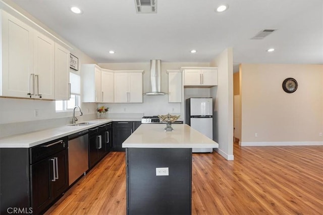 7820 Fulton Ave, North Hollywood, CA 91605 - kitchen with wall chimney range hood, stainless steel dishwasher, freestanding refrigerator, a center island, and white cabinets