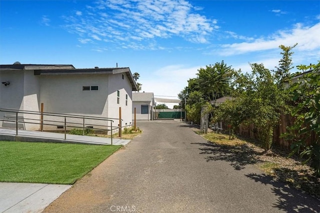7820 Fulton Ave, North Hollywood, CA 91605 - view of home's exterior with stucco siding, a gate, and asphalt driveway