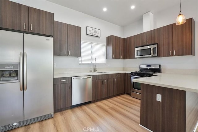 7820 Fulton Ave, North Hollywood, CA 91605 - kitchen with stainless steel appliances, light countertops, light wood-type flooring, dark brown cabinets, and recessed lighting