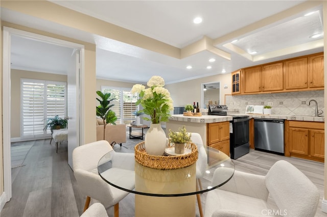 3020 Associated Rd Unit 110, Fullerton, CA 92835 - kitchen with stainless steel dishwasher, range with electric stovetop, a raised ceiling, light wood finished floors, and decorative backsplash