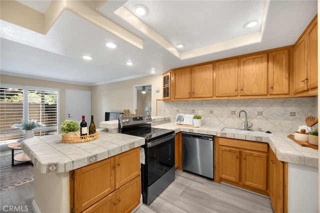 3020 Associated Rd Unit 110, Fullerton, CA 92835 - kitchen featuring stainless steel appliances, light wood finished floors, decorative backsplash, a tray ceiling, and crown molding