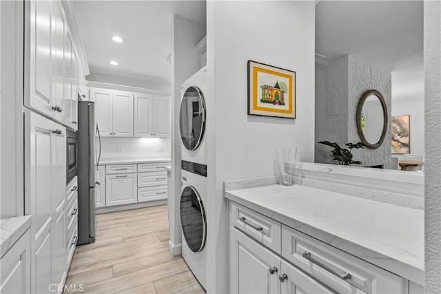 4949 Genesta Ave Unit 102, Encino, CA 91316 - washroom featuring stacked washing machine and dryer, recessed lighting, and light wood finished floors