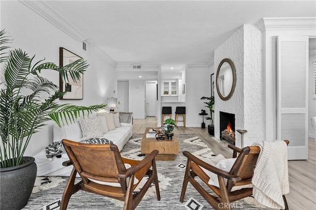 4949 Genesta Ave Unit 102, Encino, CA 91316 - living room featuring light wood-style floors, crown molding, a large fireplace, and recessed lighting