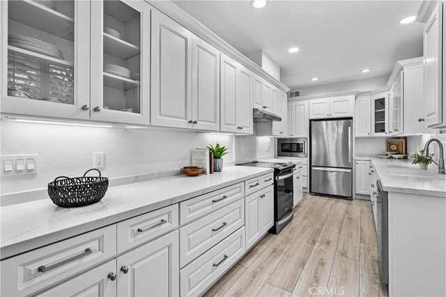 4949 Genesta Ave Unit 102, Encino, CA 91316 - kitchen with stainless steel appliances, under cabinet range hood, white cabinets, recessed lighting, and light wood-style flooring