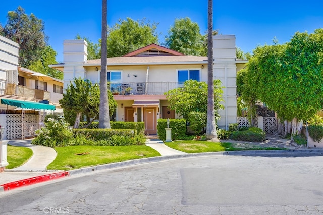 1354 Shadow Ln Unit 102, Fullerton, CA 92831 - view of front of home featuring a balcony, stucco siding, a chimney, and a front lawn