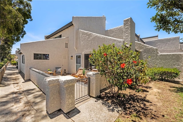 18714 Maplewood Cir, Huntington Beach, CA 92646 - rear view of property featuring stucco siding and a gate