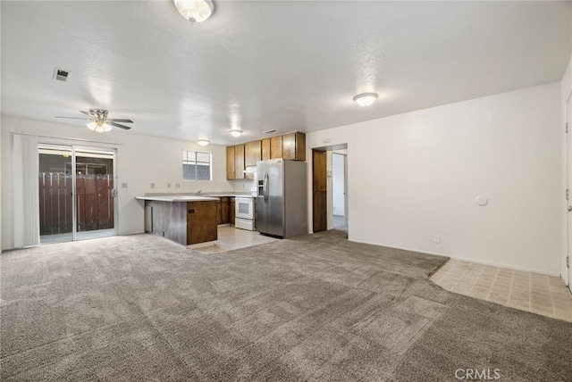 642 W 1st Ave, Chico, CA 95926 - kitchen with stainless steel fridge, open floor plan, light colored carpet, white range with electric stovetop, and under cabinet range hood