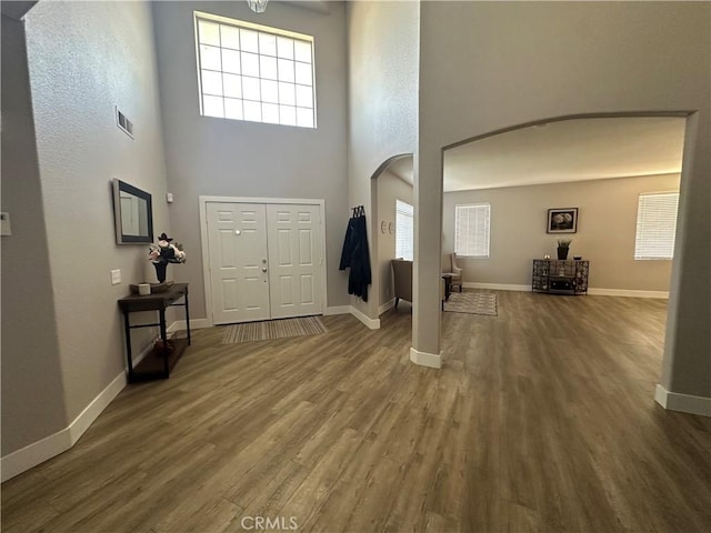 2775 Canyon View Cir, Corona, CA 92882 - foyer featuring arched walkways, wood finished floors, and a towering ceiling