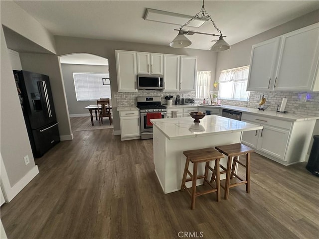 2775 Canyon View Cir, Corona, CA 92882 - kitchen featuring stainless steel appliances, arched walkways, backsplash, and white cabinetry