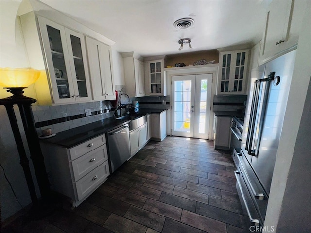 3620 Hoover St, Riverside, CA 92504 - kitchen with appliances with stainless steel finishes, dark countertops, tasteful backsplash, french doors, and glass insert cabinets