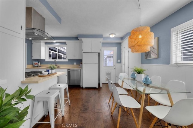 3144 W 154th Pl, Gardena, CA 90249 - kitchen with stainless steel appliances, light countertops, extractor fan, dark wood-style floors, and hanging light fixtures