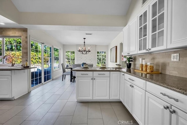 124 Marion Blvd, Fullerton, CA 92835 - kitchen featuring a peninsula, backsplash, white cabinetry, a chandelier, and glass insert cabinets