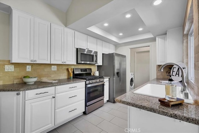 124 Marion Blvd, Fullerton, CA 92835 - kitchen featuring appliances with stainless steel finishes, white cabinetry, decorative backsplash, washer / clothes dryer, and recessed lighting