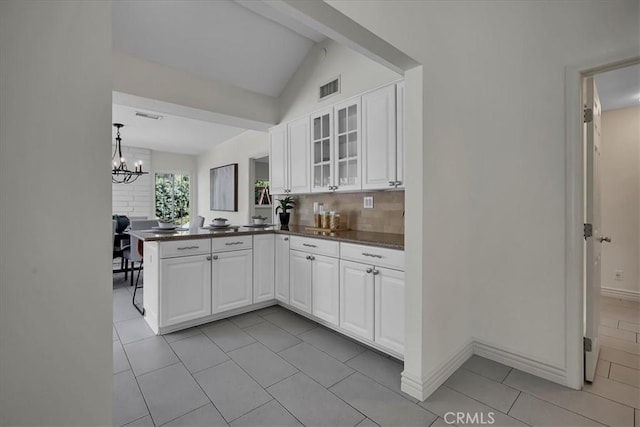124 Marion Blvd, Fullerton, CA 92835 - kitchen with white cabinets, a peninsula, a chandelier, light tile patterned flooring, and glass insert cabinets