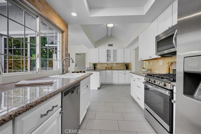 124 Marion Blvd, Fullerton, CA 92835 - kitchen featuring stainless steel appliances, backsplash, light stone countertops, glass insert cabinets, and light tile patterned floors