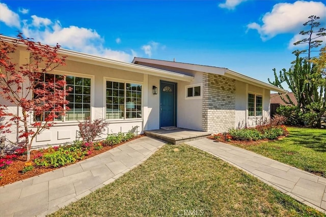 124 Marion Blvd, Fullerton, CA 92835 - ranch-style house with brick siding, a front lawn, and stucco siding