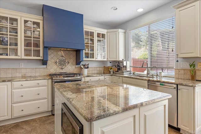 1601 Sapphire, Carlsbad, CA 92011 - kitchen with appliances with stainless steel finishes, a kitchen island, light stone counters, recessed lighting, and glass insert cabinets