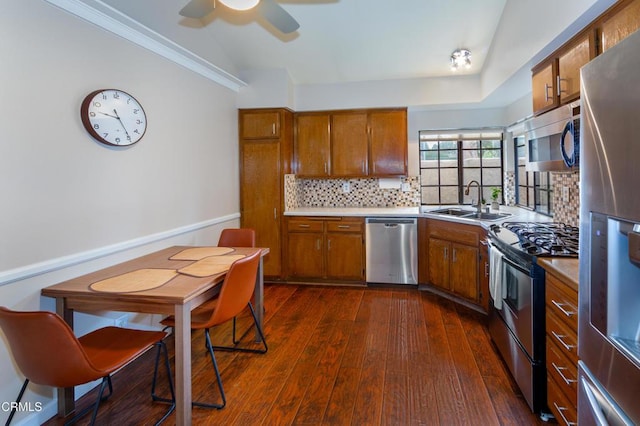 3762 Via Pacifica Walk, Oxnard, CA 93035 - kitchen with stainless steel appliances, brown cabinetry, tasteful backsplash, dark wood finished floors, and light countertops