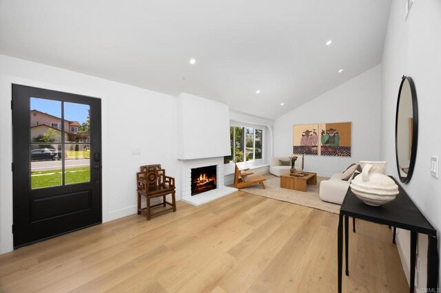 11741 Foster Rd, Los Alamitos, CA 90720 - living area with a brick fireplace, light wood-type flooring, vaulted ceiling, and recessed lighting