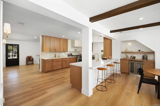 11741 Foster Rd, Los Alamitos, CA 90720 - kitchen with wine cooler, healthy amount of natural light, a kitchen bar, decorative backsplash, and recessed lighting
