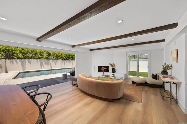 11741 Foster Rd, Los Alamitos, CA 90720 - living area featuring beamed ceiling, light wood-style flooring, a warm lit fireplace, and recessed lighting