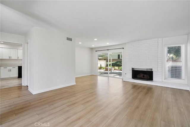 20 Mayapple Way, Irvine, CA 92612 - unfurnished living room with light wood-style flooring, a brick fireplace, and recessed lighting