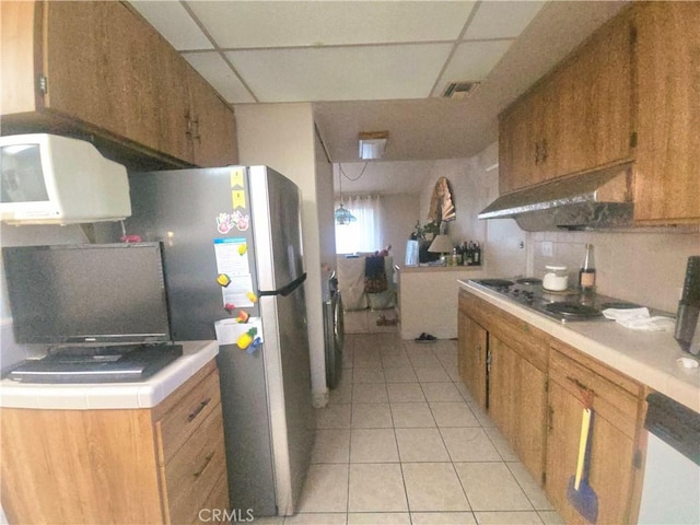 8450 Limerick Ave, Winnetka, CA 91306 - kitchen featuring electric stovetop, a paneled ceiling, light countertops, light tile patterned floors, and brown cabinets