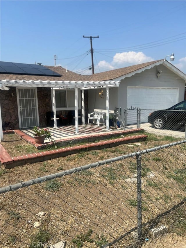 26832 6th St, Highland, CA 92346 - view of side of home featuring roof mounted solar panels, an attached garage, driveway, and a patio