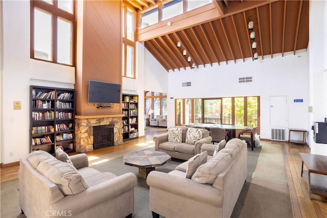 7205 Summertime Ln, Culver City, CA 90230 - living room featuring high vaulted ceiling, wood-type flooring, a stone fireplace, built in features, and a wood ceiling with exposed beams