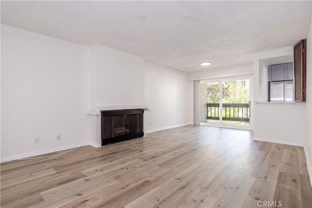 7205 Summertime Ln, Culver City, CA 90230 - unfurnished living room with a fireplace, light wood finished floors, and a textured ceiling
