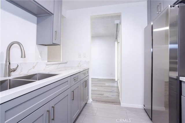7205 Summertime Ln, Culver City, CA 90230 - kitchen with freestanding refrigerator, gray cabinets, light stone countertops, and light tile patterned floors