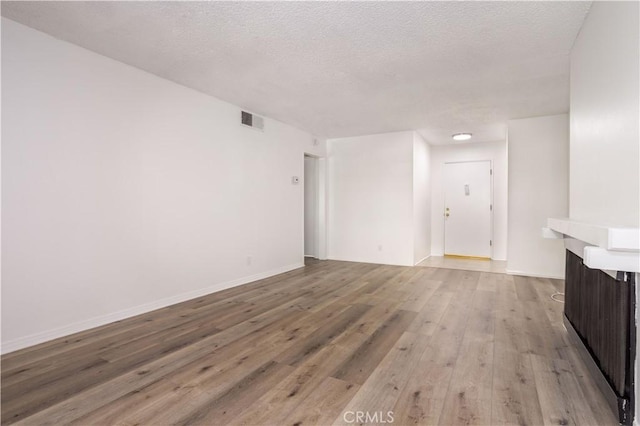 7205 Summertime Ln, Culver City, CA 90230 - unfurnished living room with light wood finished floors and a textured ceiling
