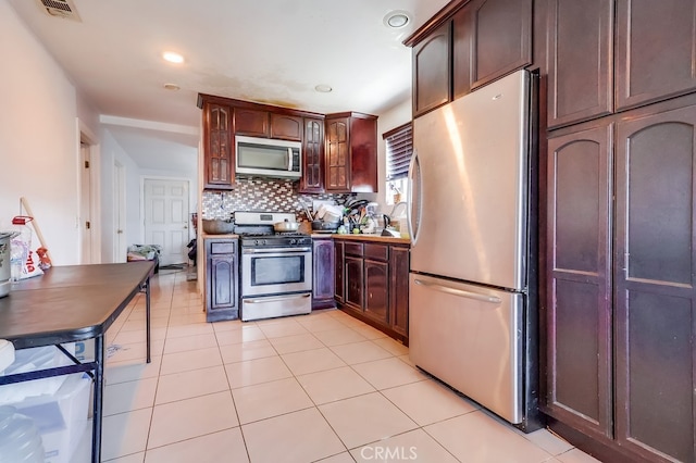 1270 S Hicks Ave, Los Angeles, CA 90023 - kitchen featuring appliances with stainless steel finishes, backsplash, glass insert cabinets, light tile patterned floors, and recessed lighting