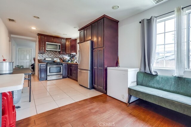 1270 S Hicks Ave, Los Angeles, CA 90023 - kitchen featuring appliances with stainless steel finishes, healthy amount of natural light, tasteful backsplash, light wood-type flooring, and recessed lighting