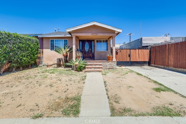 1270 S Hicks Ave, Los Angeles, CA 90023 - view of front of house with stucco siding, a gate, and a porch