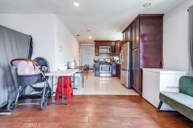 1270 S Hicks Ave, Los Angeles, CA 90023 - kitchen featuring stainless steel appliances, light wood-style floors, recessed lighting, dark brown cabinets, and tasteful backsplash