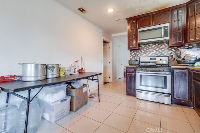 1270 S Hicks Ave, Los Angeles, CA 90023 - kitchen featuring stainless steel appliances, glass insert cabinets, tasteful backsplash, light tile patterned floors, and recessed lighting