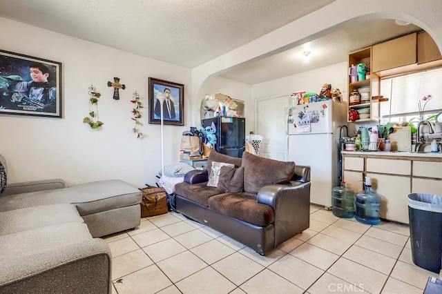 1270 S Hicks Ave, Los Angeles, CA 90023 - living room with arched walkways, light tile patterned flooring, and a textured ceiling