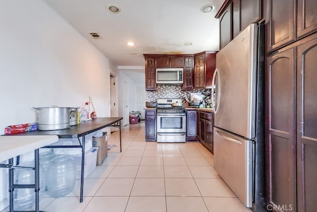 1270 S Hicks Ave, Los Angeles, CA 90023 - kitchen featuring stainless steel appliances, decorative backsplash, light tile patterned floors, recessed lighting, and glass insert cabinets