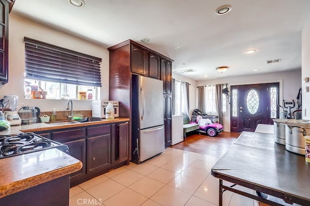 1270 S Hicks Ave, Los Angeles, CA 90023 - kitchen with freestanding refrigerator, recessed lighting, light tile patterned floors, and dark brown cabinetry