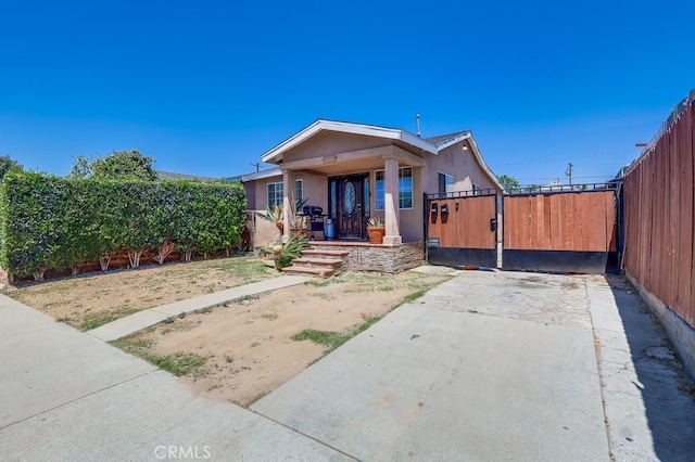 1270 S Hicks Ave, Los Angeles, CA 90023 - view of front of house featuring covered porch, driveway, and a gate