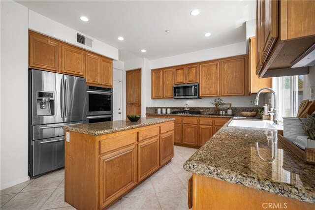 420 Augusta Ln, Placentia, CA 92870 - kitchen featuring appliances with stainless steel finishes, dark stone countertops, a kitchen island, light tile patterned flooring, and recessed lighting