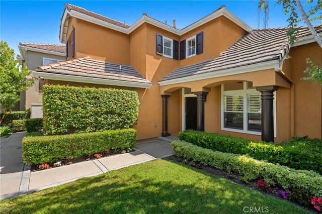 61 Clermont, Newport Coast, CA 92657 - view of front of home with stucco siding, a front yard, and a tile roof