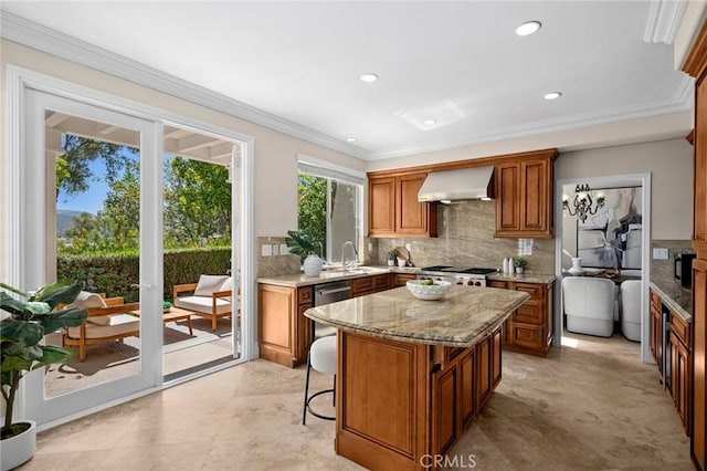 61 Clermont, Newport Coast, CA 92657 - kitchen with wall chimney range hood, tasteful backsplash, brown cabinets, light stone counters, and a kitchen island