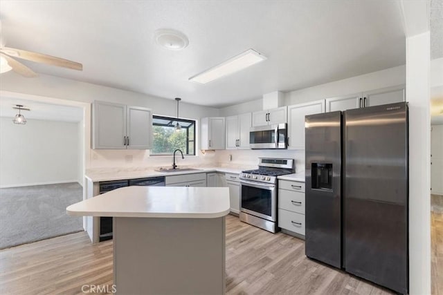 21999 Riverside Ave, Red Bluff, CA 96080 - kitchen featuring stainless steel appliances, light countertops, light wood-style floors, a center island, and ceiling fan