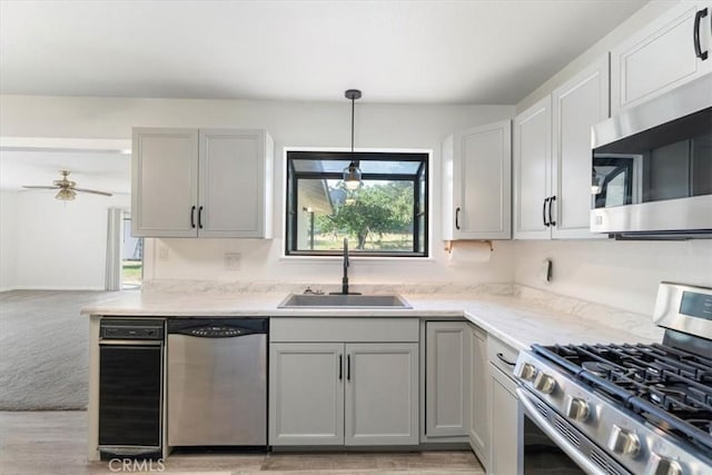 21999 Riverside Ave, Red Bluff, CA 96080 - kitchen featuring stainless steel appliances, gray cabinetry, a ceiling fan, light wood finished floors, and hanging light fixtures
