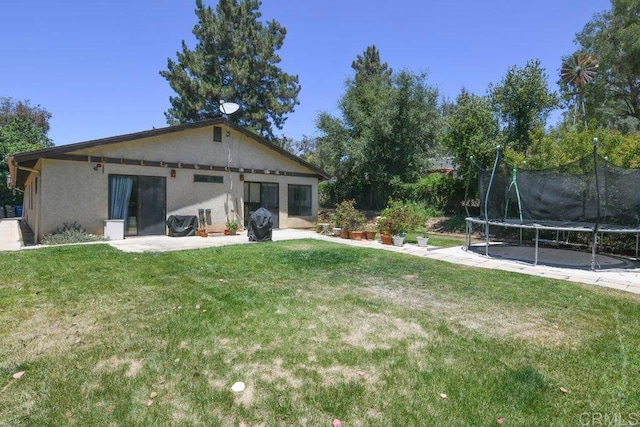 3096 Coral Tree Ln, Fallbrook, CA 92028 - rear view of house with a trampoline, a patio area, a yard, and stucco siding