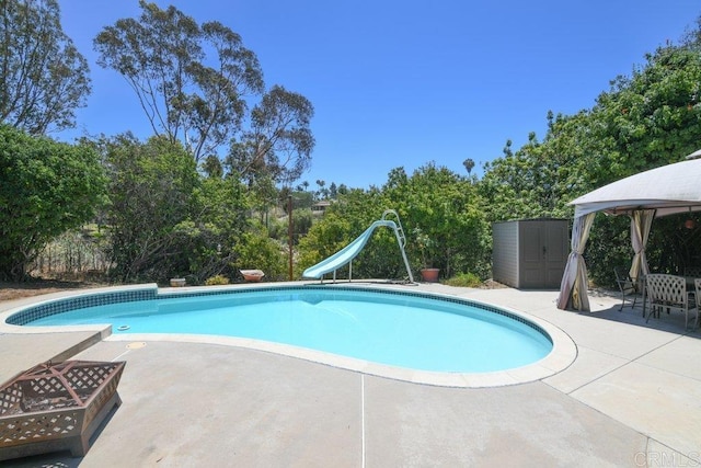 3096 Coral Tree Ln, Fallbrook, CA 92028 - view of pool featuring a gazebo, a water slide, a patio area, a storage unit, and view of wooded area