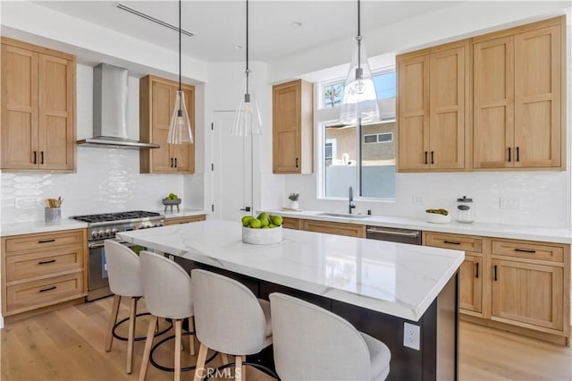 2102 Marshallfield Ln Unit A, Redondo Beach, CA 90278 - kitchen with wall chimney range hood, stainless steel appliances, light wood finished floors, and a kitchen bar